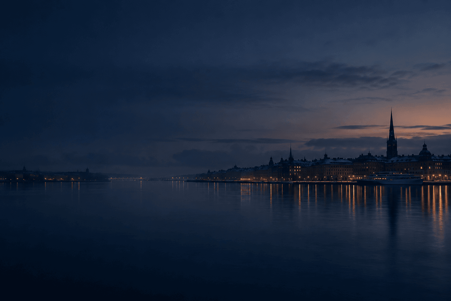 A Nordic harbour city at dusk seen across calm water